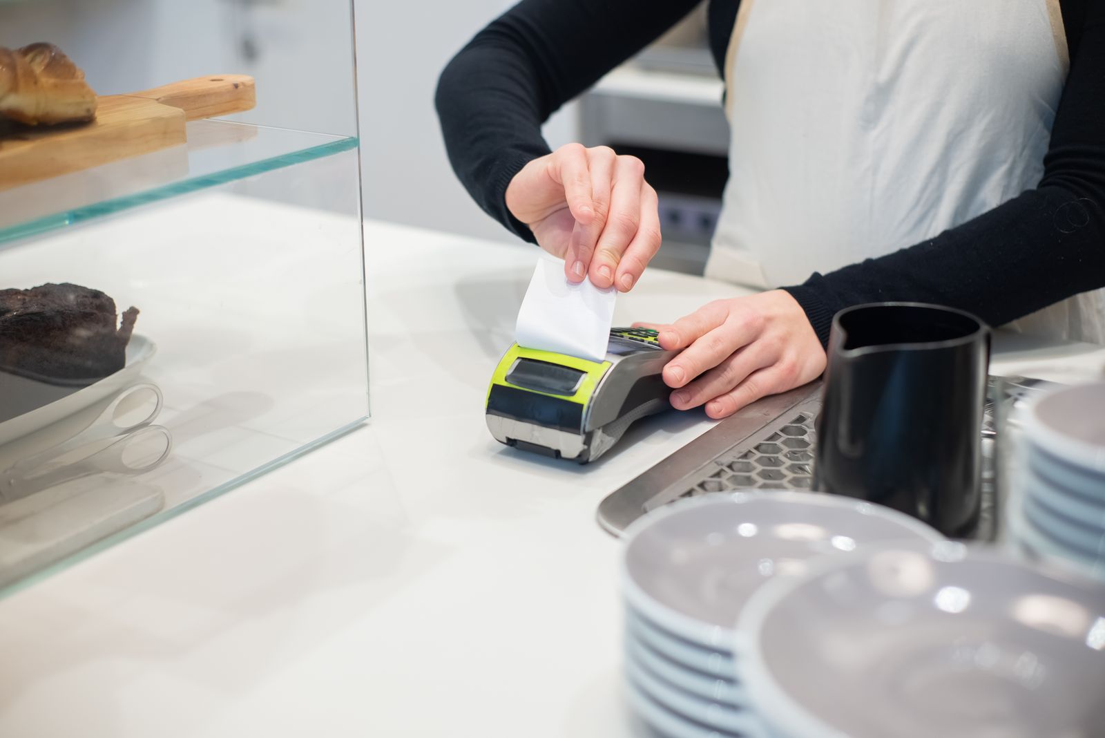 Small business owner reviewing sales receipts at the counter